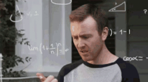 A Man Is Standing In Front Of A Chalkboard With Math Problems On It . GIF