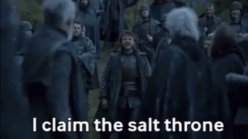 A Man Is Standing In Front Of A Crowd Of People And Yelling . GIF