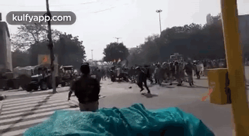 A Man Is Standing In Front Of A Crowd Of People On A City Street . GIF
