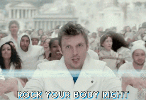 A Man Is Standing In Front Of A Crowd With The Words Rock Your Body Right Behind Him GIF