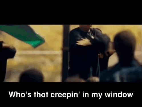 A Man Is Standing In Front Of A Crowd With The Words " Who 'S That Creepin ' In My Window " Below Him GIF