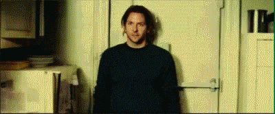 A Man Is Standing In Front Of A Door In A Room . GIF
