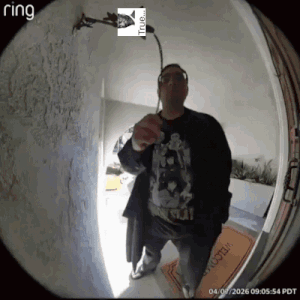 A Man Is Standing In Front Of A Door With A Ring Logo On It GIF