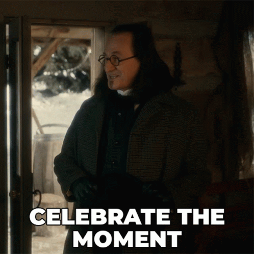 A Man Is Standing In Front Of A Door With The Words " Celebrate The Moment " Written Below Him GIF