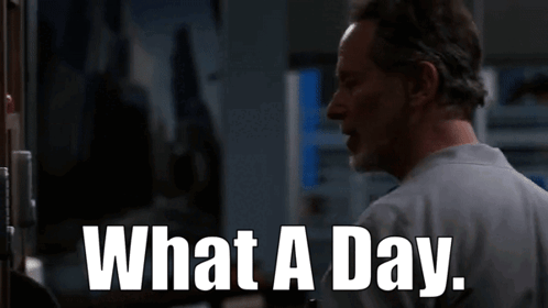 A Man Is Standing In Front Of A Door With The Words What A Day Written On It . GIF