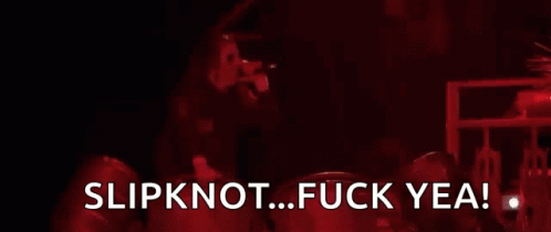 A Man Is Standing In Front Of A Fire With The Words Slipknot Fuck Yea GIF
