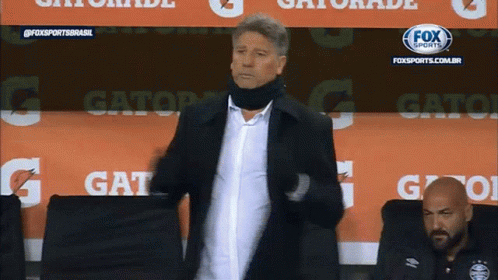 A Man Is Standing In Front Of A Gatorade Advertisement GIF
