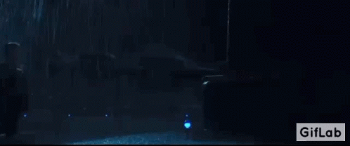 A Man Is Standing In Front Of A Giant Monster In A Dark Room With A Giflab Logo In The Corner GIF