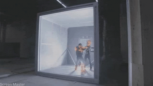 A Man Is Standing In Front Of A Glass Box That Says Screen Master On It GIF