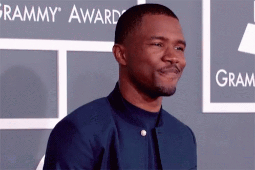 A Man Is Standing In Front Of A Grammy Award Sign GIF