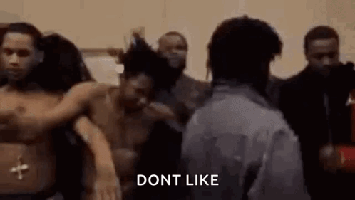A Man Is Standing In Front Of A Group Of People Without Shirts . GIF