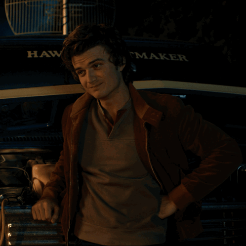 A Man Is Standing In Front Of A Hawk Maker Truck GIF