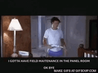 A Man Is Standing In Front Of A Lamp In A Room Holding A Remote Control . GIF