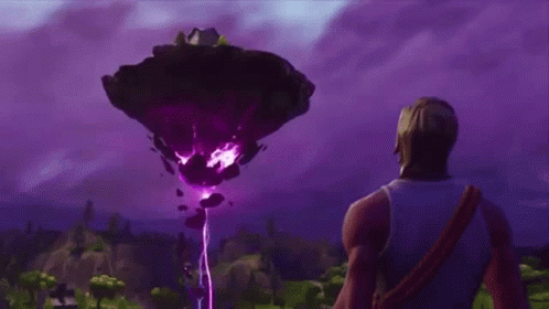 A Man Is Standing In Front Of A Large Purple Object In The Sky . GIF