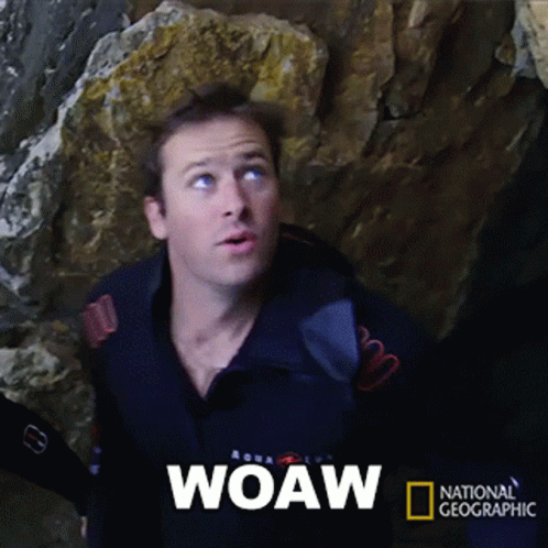 A Man Is Standing In Front Of A Large Rock And The Word Woaw Is On The Screen GIF