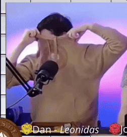 A Man Is Standing In Front Of A Microphone And The Name Dan Leonidas Is On The Bottom Right GIF