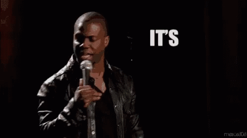 A Man Is Standing In Front Of A Microphone With The Words `` It 'S About To Go Down '' Written In White Letters . GIF