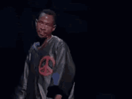 A Man Is Standing In Front Of A Microphone With The Words Next Time Written On The Screen Behind Him . GIF