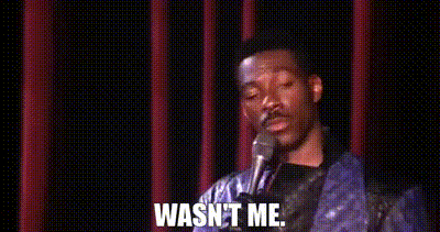 A Man Is Standing In Front Of A Microphone With The Words `` Wasn 'T Me '' Written On It . GIF