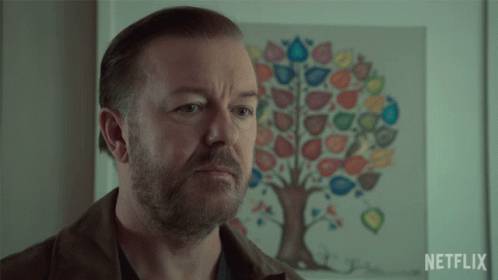 A Man Is Standing In Front Of A Netflix Poster GIF