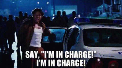 A Man Is Standing In Front Of A Police Car And Saying `` Say , I 'M In Charge ! `` . GIF