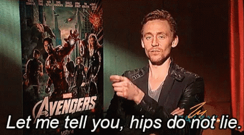 A Man Is Standing In Front Of A Poster For The Avengers GIF