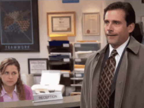 A Man Is Standing In Front Of A Reception Desk GIF