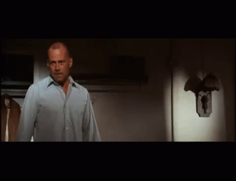 A Man Is Standing In Front Of A Refrigerator Door . GIF