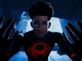 A Man Is Standing In Front Of A Screen With His Arms Outstretched In A Dark Room . GIF