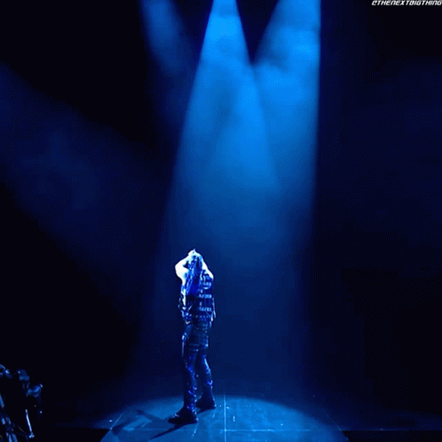 A Man Is Standing In Front Of A Sign That Says Damian Presley GIF