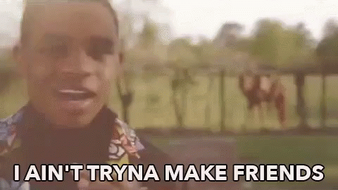 A Man Is Standing In Front Of A Sign That Says I Ain 'T Tryna Make Friends GIF