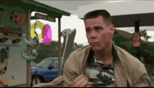 A Man Is Standing In Front Of A Sign That Says L32 On It GIF