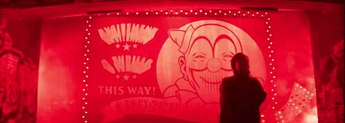 A Man Is Standing In Front Of A Sign That Says This Way On It GIF