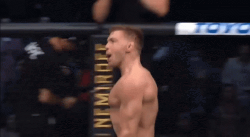 A Man Is Standing In Front Of A Sign That Says ' Ufc ' On It . GIF