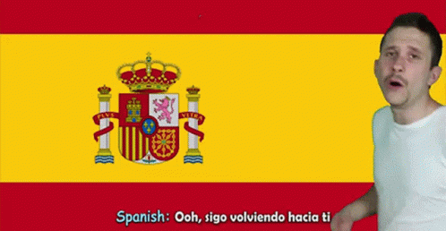 A Man Is Standing In Front Of A Spanish Flag GIF