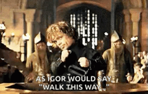 A Man Is Standing In Front Of A Table With A Group Of People Standing Around Him . GIF