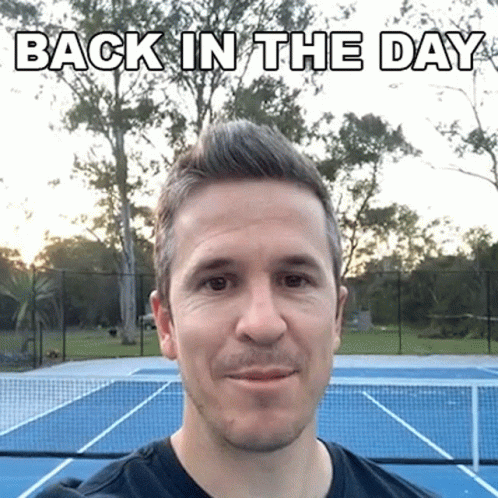 A Man Is Standing In Front Of A Tennis Court With The Words Back In The Day Written Above Him GIF