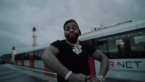 A Man Is Standing In Front Of A Train That Says R-Net On The Side GIF