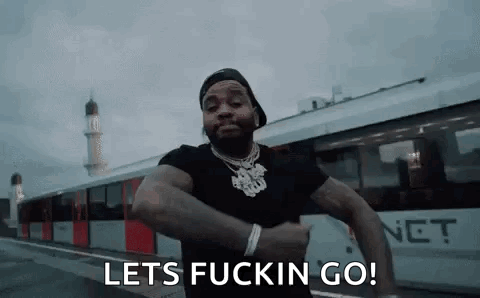 A Man Is Standing In Front Of A Train With The Words `` Lets Fuckin Go '' Written On His Face . GIF