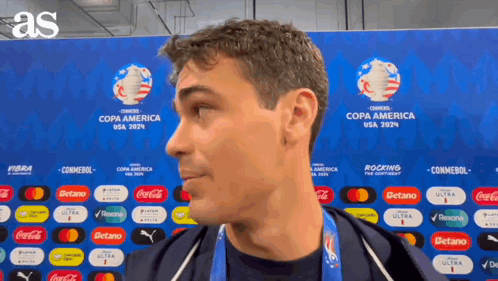 A Man Is Standing In Front Of A Wall That Says Copa America Usa 2024 GIF