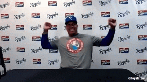 A Man Is Standing In Front Of A Wall That Says Royals GIF