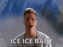 A Man Is Standing In Front Of A Wall With The Words Ice Ice Baby On It . GIF