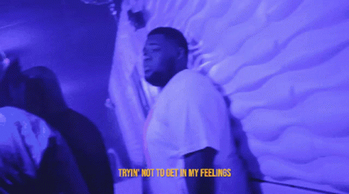 A Man Is Standing In Front Of A Wall With The Words Tryin ' Not To Get In My Feelings On The Bottom GIF