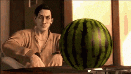 A Man Is Standing In Front Of A Watermelon On A Table . GIF