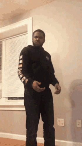 A Man Is Standing In Front Of A Window In A Living Room . GIF
