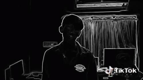 A Man Is Standing In Front Of A Window With A Tiktok Logo On The Bottom Right GIF