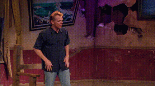 A Man Is Standing In Front Of A Window With His Hands Outstretched And Says Hey GIF
