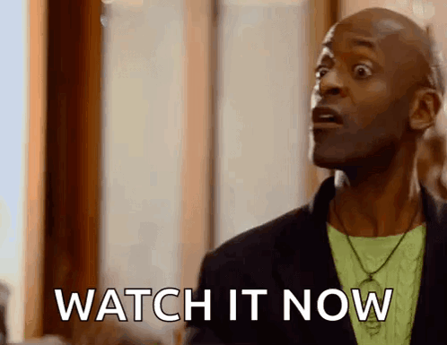 A Man Is Standing In Front Of A Window With His Mouth Open And Says `` Watch It Now '' . GIF