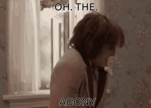 A Man Is Standing In Front Of A Window With The Words " Oh The Agony " Written On The Screen . GIF
