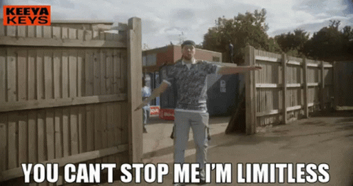 A Man Is Standing In Front Of A Wooden Fence With The Words " You Can 'T Stop Me I 'M Limitless " GIF